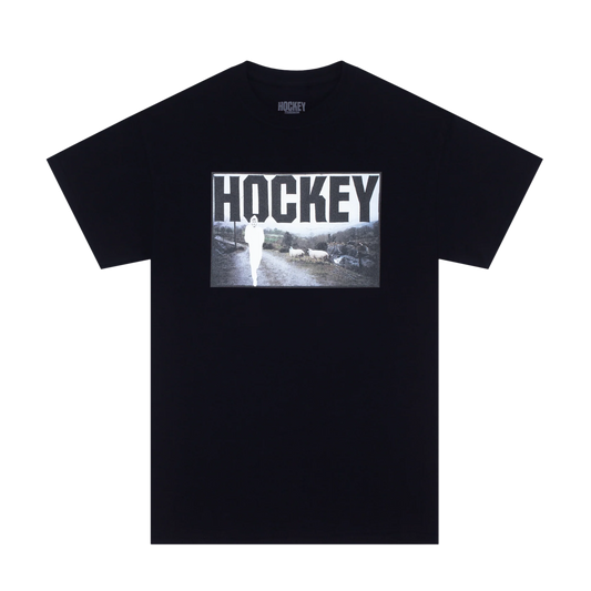 A black short-sleeve t-shirt with a graphic print on the front featuring the word 'HOCKEY' in bold white letters over a black-and-white photo of a player on ice. The brand name 'HOCKEY' is also printed inside the collar.
