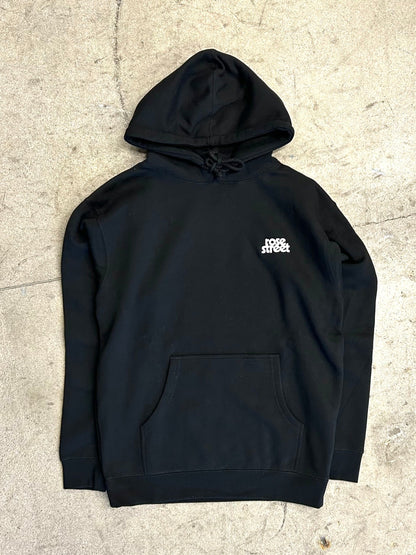 Black hoodie with a logo on the chest against a textured beige background