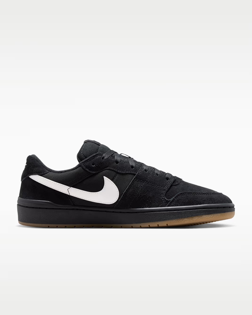 Black sneaker with green accents on a gray background