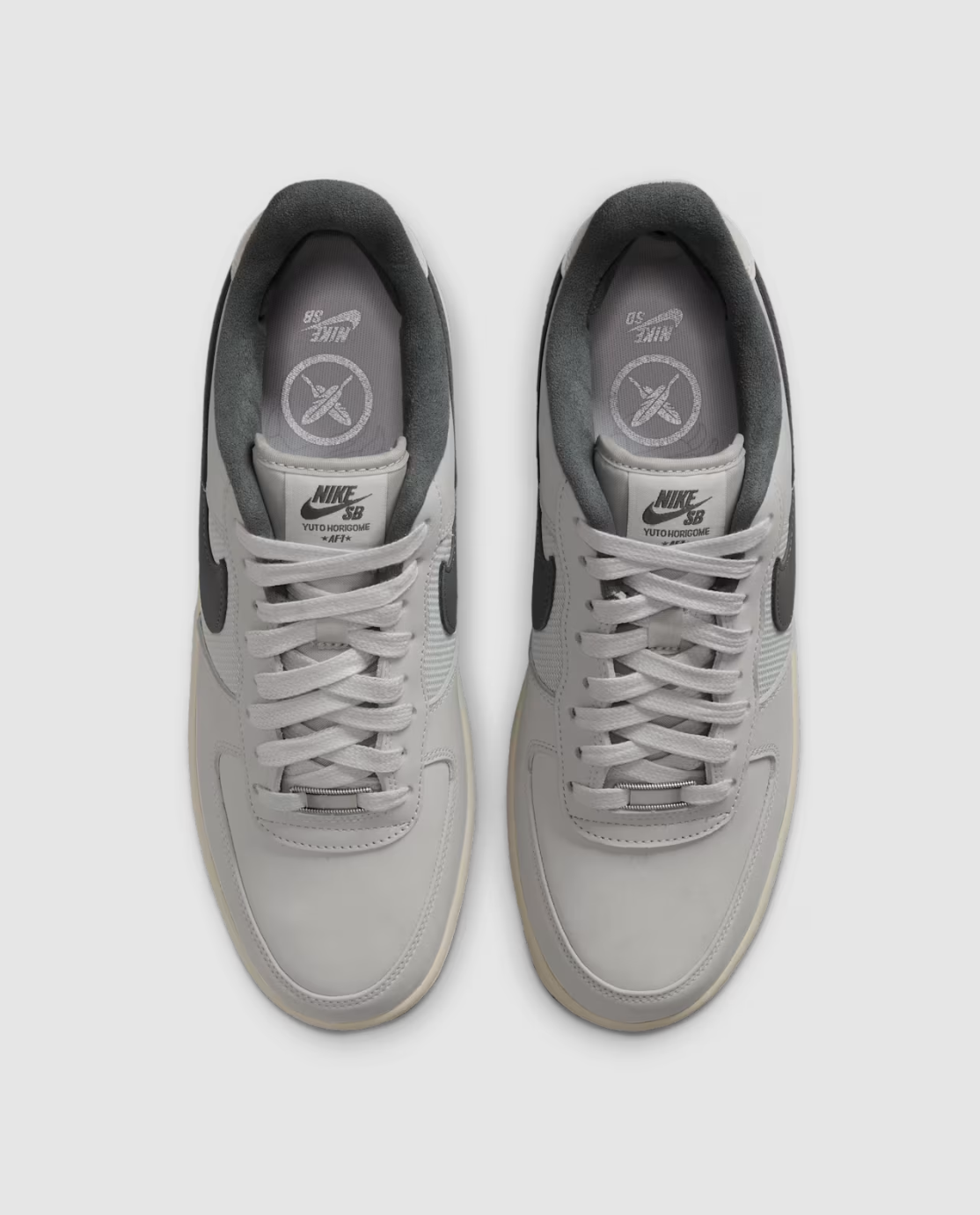 A pair of Nike Air Force 1 Low sneakers in light gray, shown from a top-down view on a light gray background.