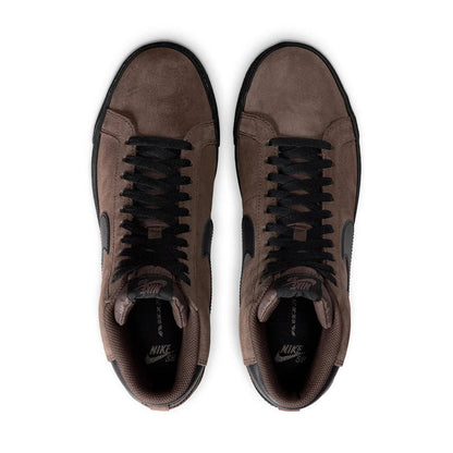 Pair of brown sneakers with black laces on a white background